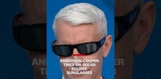Anderson Cooper tries on solar eclipse sunglasses
